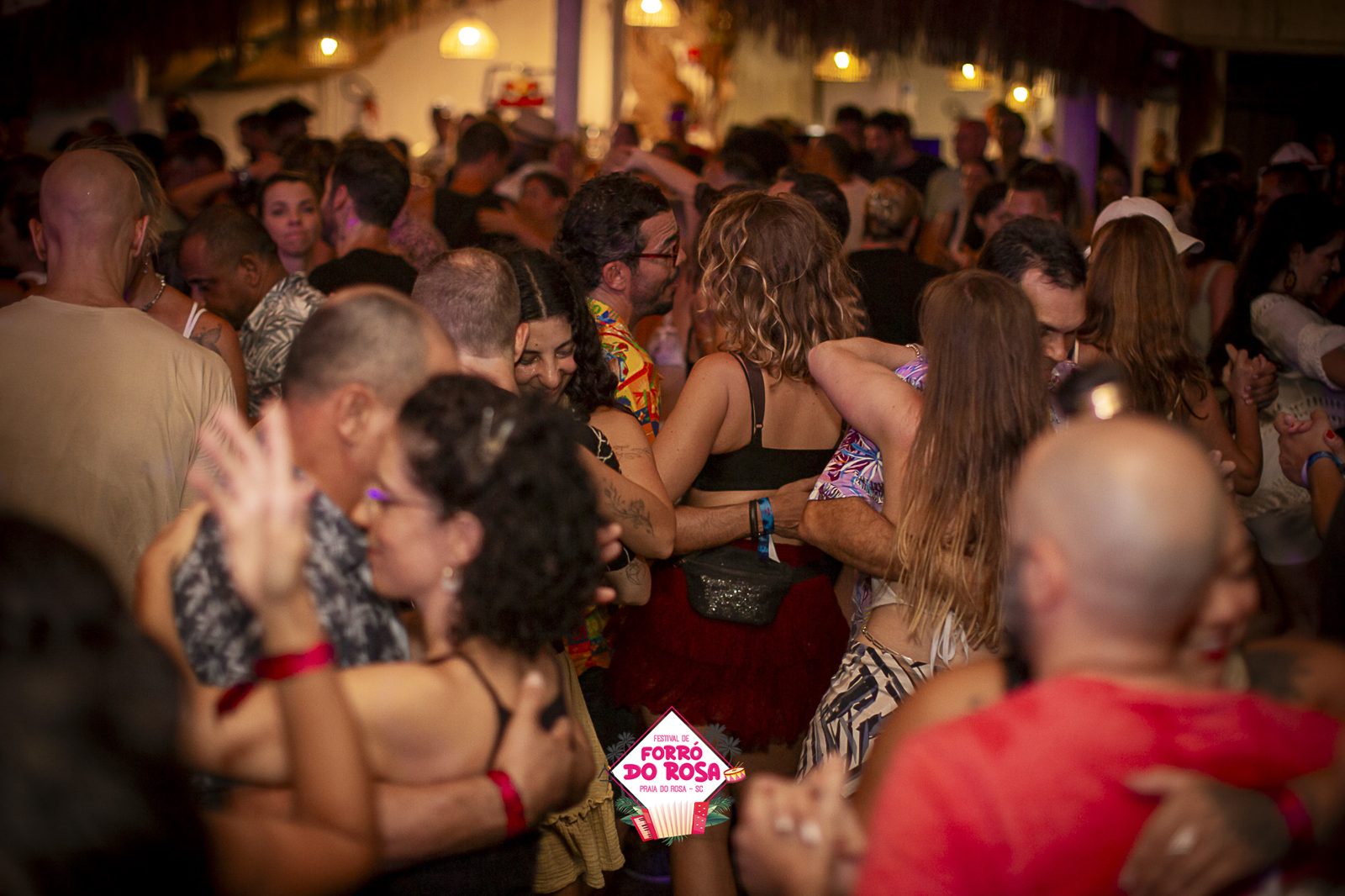Baile cheio de gente dançando forró na madrugada