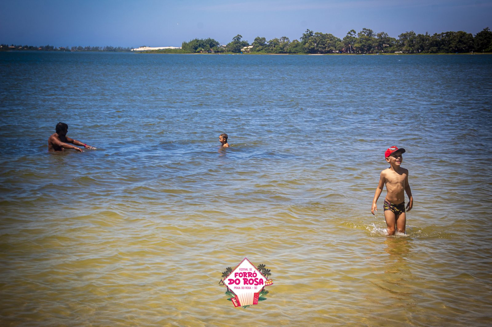 Público do festival se refrescando na lagoa em dia de sol